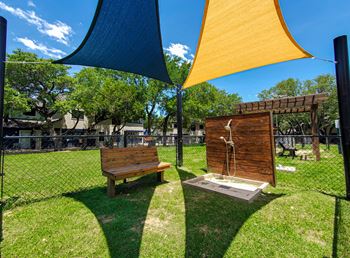 a bench and a shower in a park under umbrellas